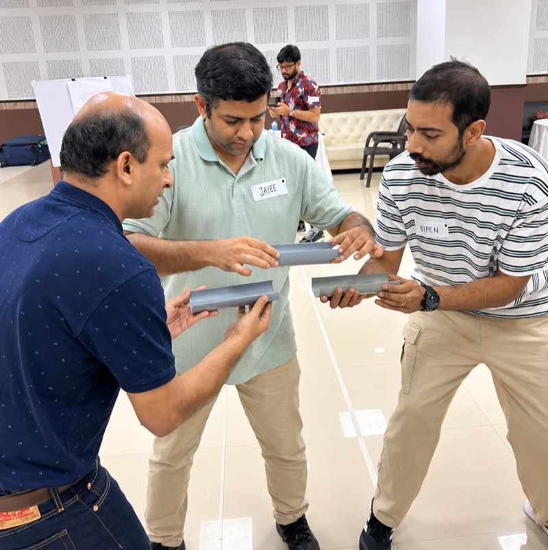 Three managers working out how to line up the sections of a channel they are each holding