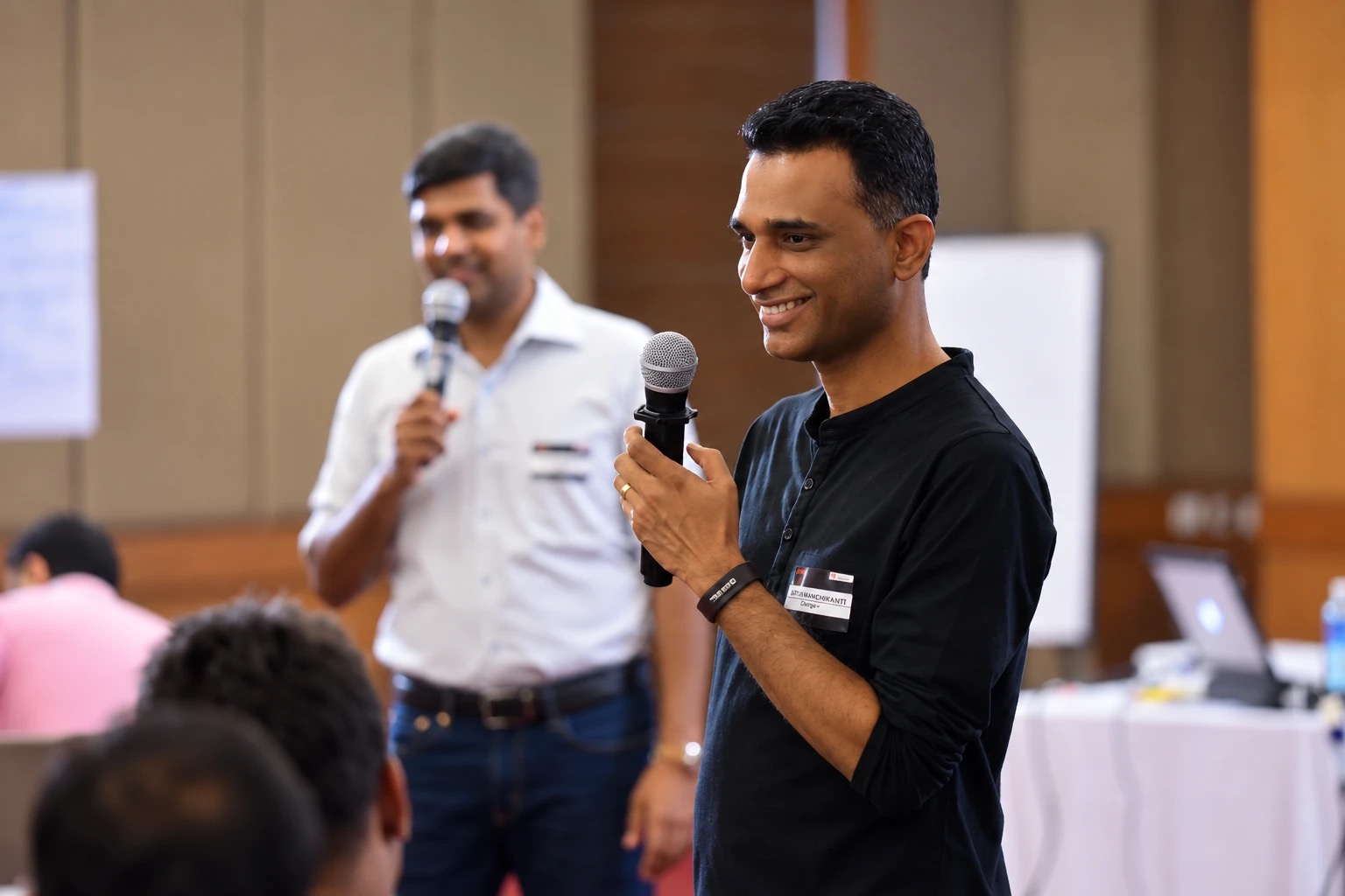 Two Change+ facilitators co-leading a session, both holding microphones